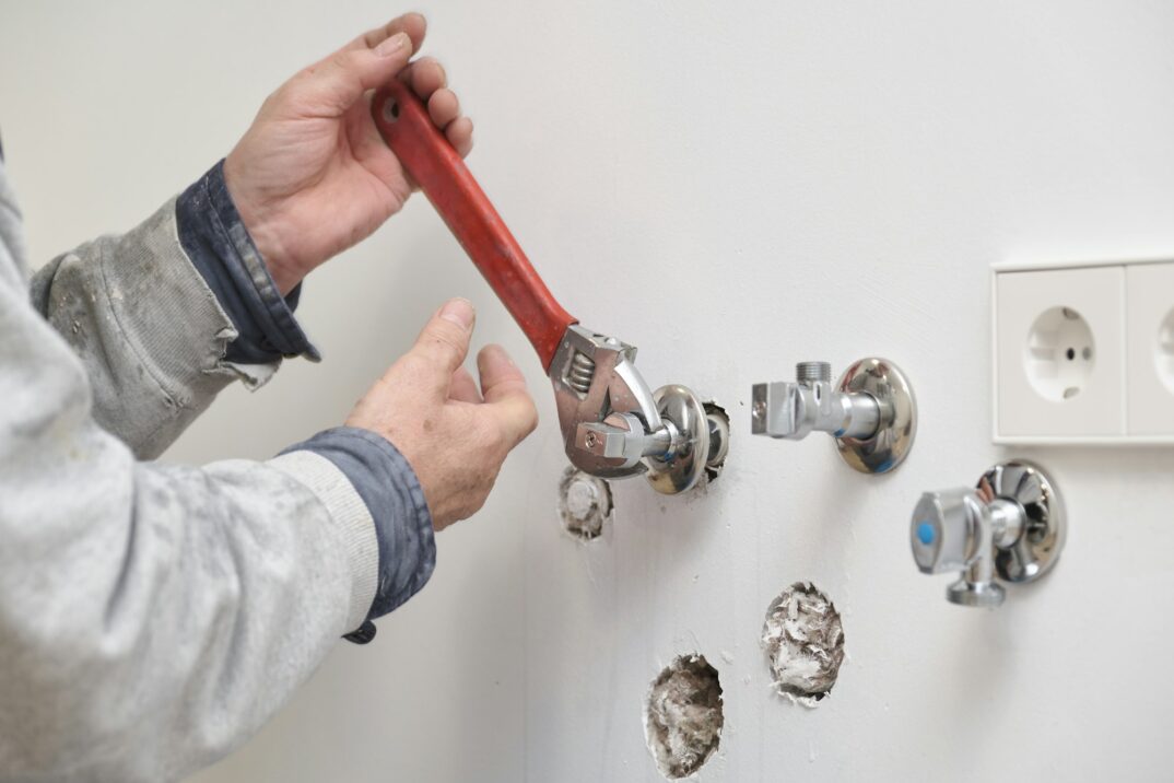plumber-screwing-plumbing-fittings-with-an-adjustable-wrench-.jpg
